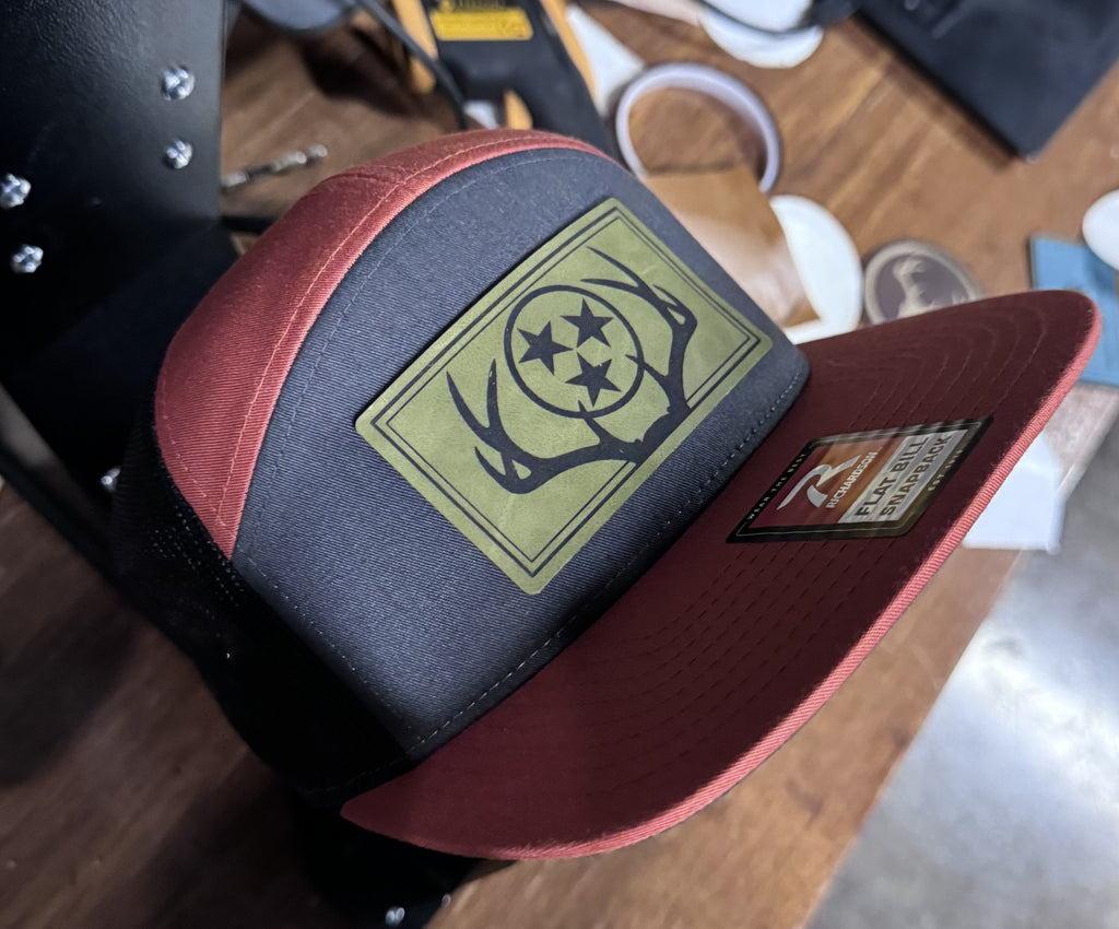 Richardson 168 - 7 Panel Trucker Hat – Charcoal/Burnt Orange/Black - Custom Leatherette Patch w Your Logo
